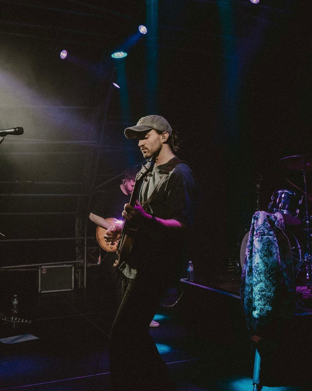 The Houndcats guitarist performing beneath colourful stage lighting