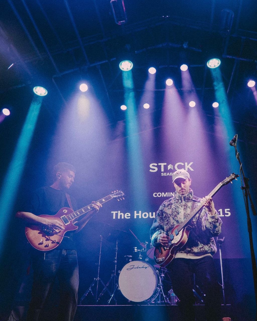 Two members of The Houndcats performing together under blue stage lights